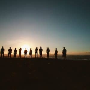 A group of people stood in front of a sunset