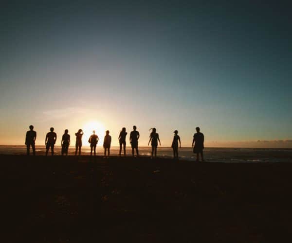 A group of people stood in front of a sunset